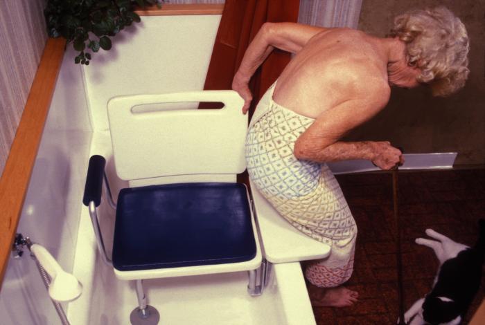 Elderly woman using a bathtub balance seat