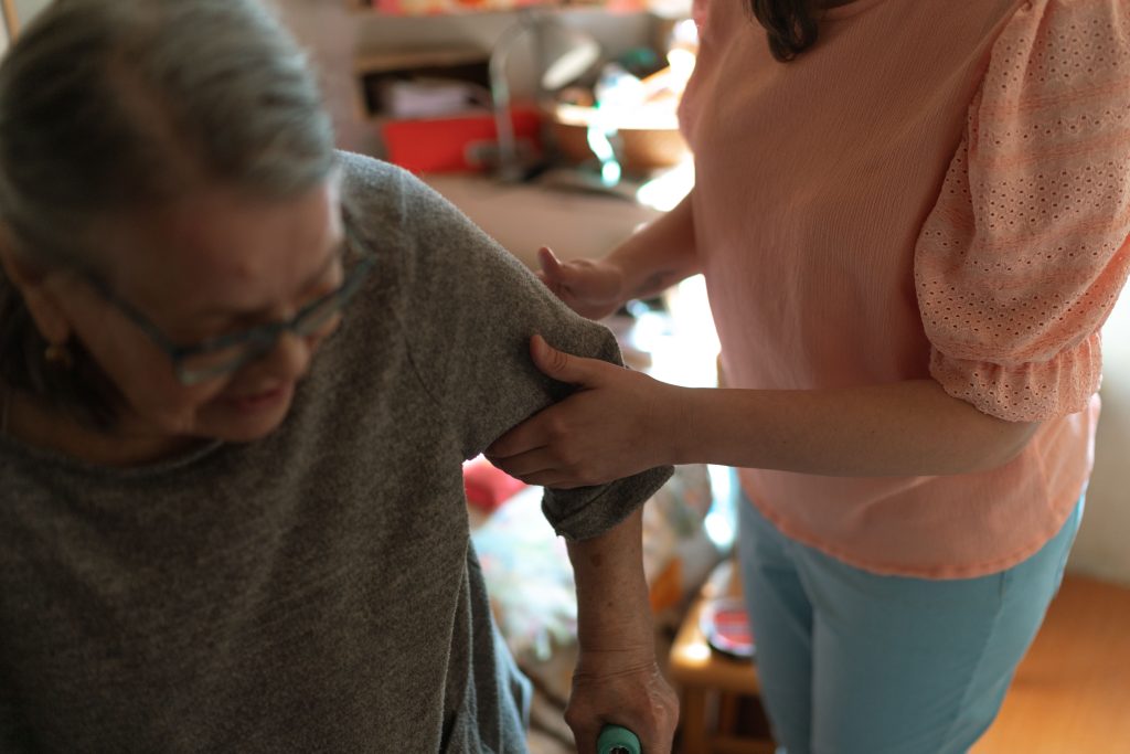 Caregiver offering steady support to an older woman at home